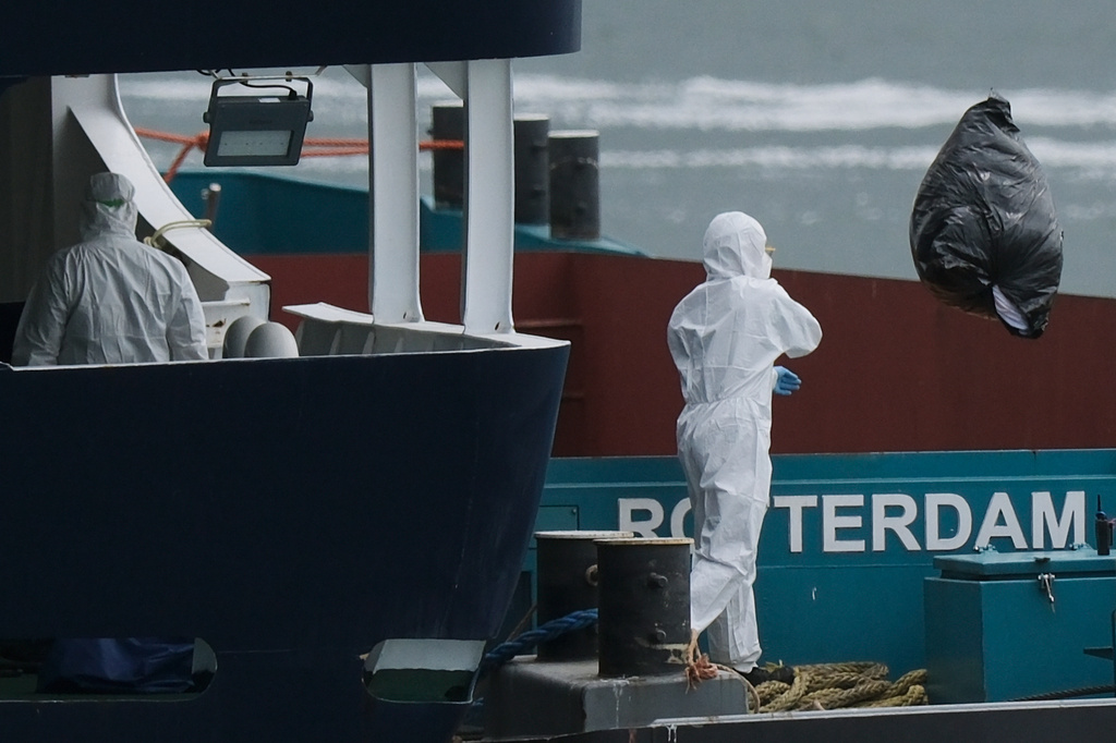 People in protective gear remove waste from the MV Hondius cruise ship after its arrival at the Port of Rotterdam, Netherlands, Monday, May 18, 2026. (AP Photo/Patrick Post)