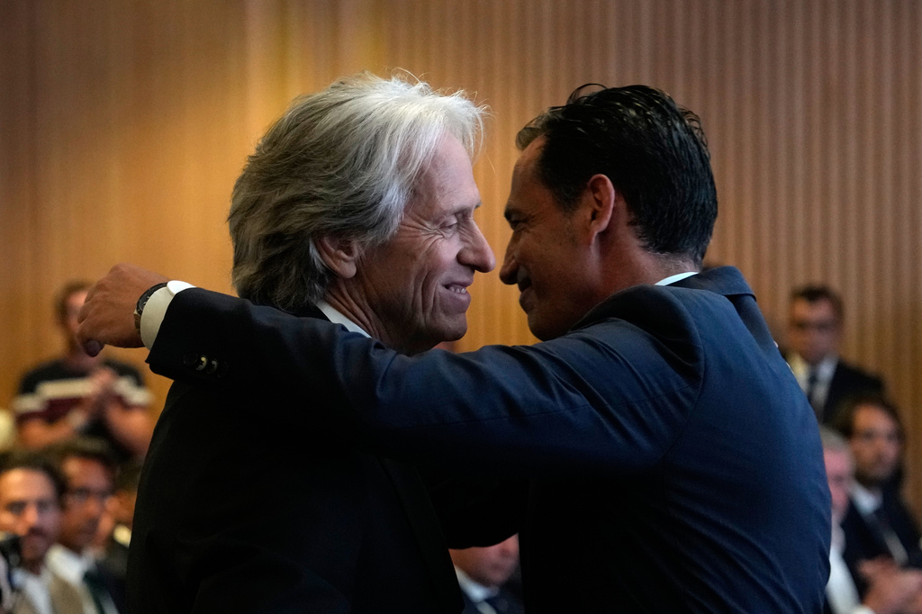 Jorge Jesus, left, is embraced by Portuguese Federation President Jorge Proenca after being presented to the media as the new Portugal soccer head coach at the Portuguese Football Federation in Oeiras, outside Lisbon, Friday, July 10, 2026. (AP Photo/Armando Franca)