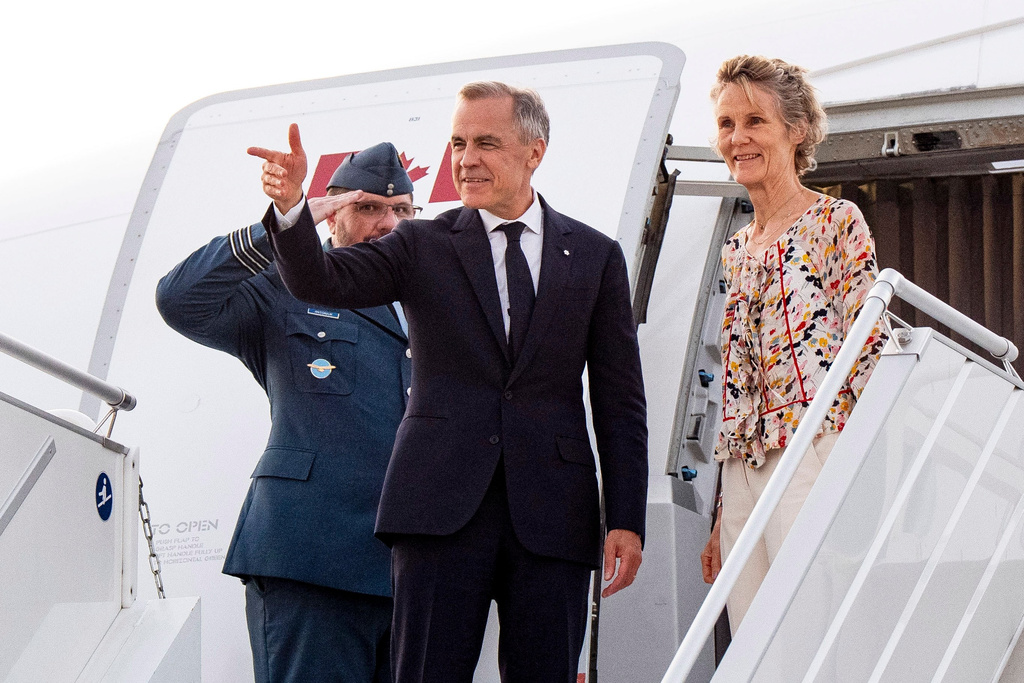 Canada's Prime Minister Mark Carney and Diana Fox Carney board a government plane, in Toronto on Thursday, June 11, 2026. (Christopher Katsarov/The Canadian Press via AP)
