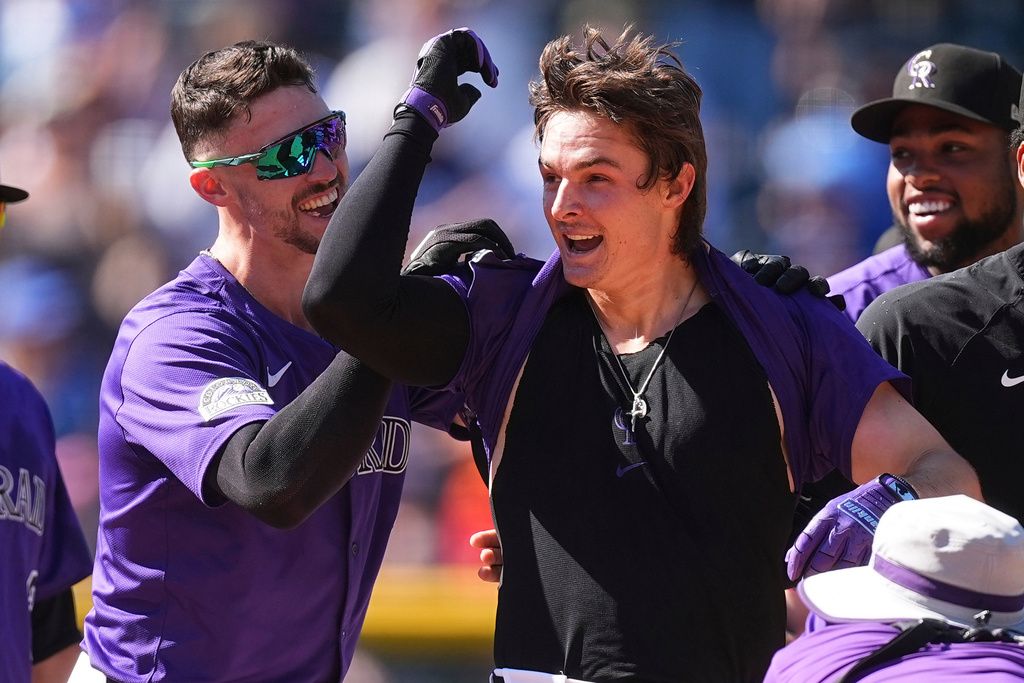Colorado Rockies' Brenton Doyle, left, congratulates Mickey Moniak, second from left, after Moniak's walkoff RBI single off Chicago Cubs relief pitcher Daniel Palencia in the ninth inning of a baseball game Sunday, Aug. 31, 2025, in Denver. (AP Photo/David Zalubowski)