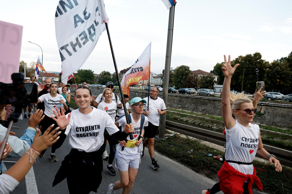 People welcome a group of university students at the end of their cycling tour of the Balkan country ahead of an early election next month challenging populist President Aleksandar Vucic, in Kragujevac, Serbia, Saturday, Sept. 26, 2026. (AP Photo/Marko Drobnjakovic)