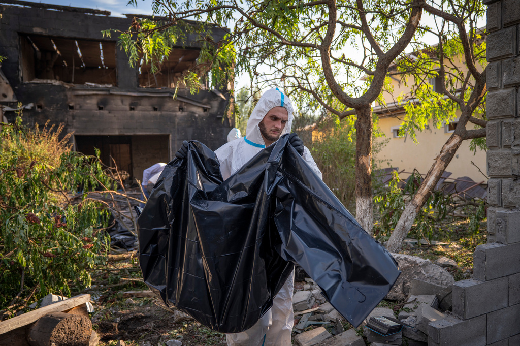 An emergency worker carries a bag with a body of a civilian after a nursing home for the elderly and people with disabilities was severely damaged following Russia's air attack, in the village of Myla, Kyiv region, Ukraine, Saturday, Aug. 29, 2026. (AP Photo/Dan Bashakov)