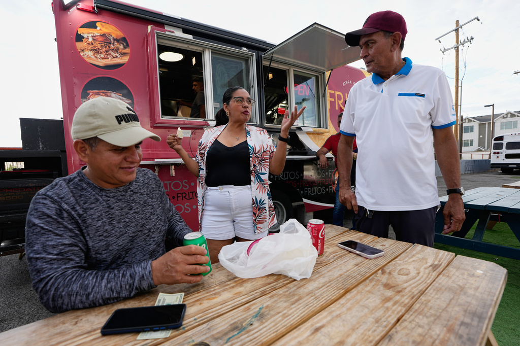 Venezuelans gather outside a food truck on Wednesday, July 15, 2026, in Midvale, Utah. (AP Photo/Gregory Bull)