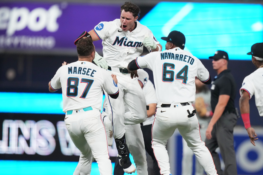 Miami Marlins' Griffin Conine, center, celebrates after hitting a walk off single to score Heriberto Hernández and defeat the Philadelphia Phillies in the the ninth inning of a baseball game, Monday, July 27, 2026, in Miami. (AP Photo/Lynne Sladky)