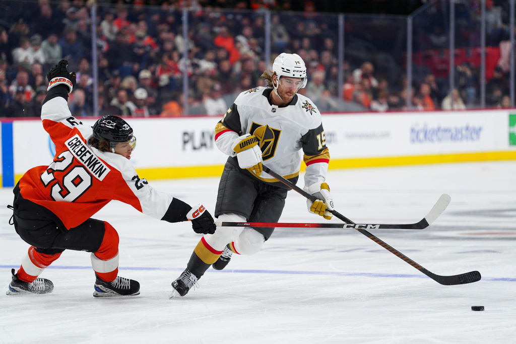 Vegas Golden Knights' Noah Hanifin, right, skates the puck past Philadelphia Flyers' Nikita Grebenkin during the first period of an NHL hockey game, Thursday, Dec. 11, 2025, in Philadelphia. (AP Photo/Derik Hamilton)
