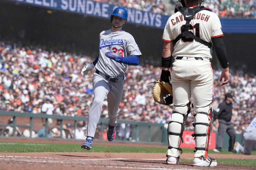 Los Angeles Dodgers' Kyle Tucker (23) scores a run past San Francisco Giants catcher Drew Cavanaugh (61) on a sacrifice hit by Andy Pages during the fourth inning of a baseball game Sunday, Sept. 27, 2026, in San Francisco. (AP Photo/Tony Avelar)