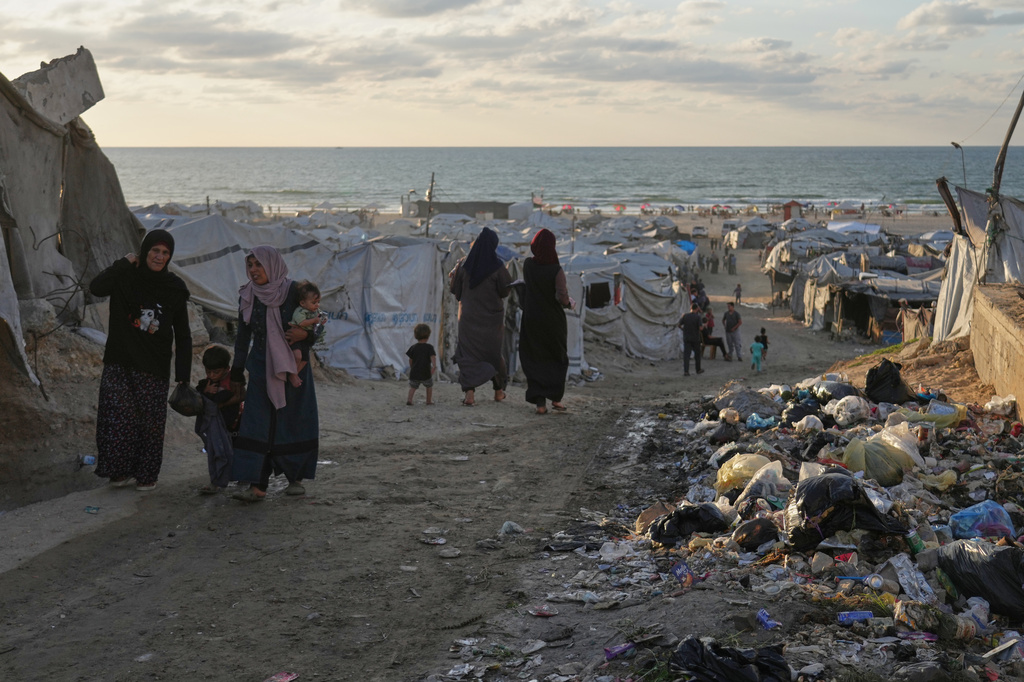 Women walk along a street surrounded by tents sheltering displaced Palestinians, in Gaza City, Saturday, Sept. 26, 2026. (AP Photo/Jehad Alshrafi)