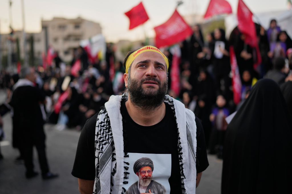 A mourner wearing a shirt depicting the slain Iranian Supreme Leader Ayatollah Ali Khamenei weeps while gathered in Islamic Revolution Square for Khamenei's funeral procession in Tehran, Iran, Monday, July 6, 2026. (AP Photo/Altaf Qadri)