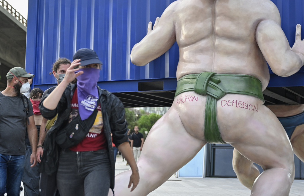 Protesters walk past a sculpture with the inscription that reads "Macron resign" during a gathering of the "Block Everything" movement in Marseille, south of France, Wednesday, Sept. 10, 2025. (AP Photo/Philippe Magoni)