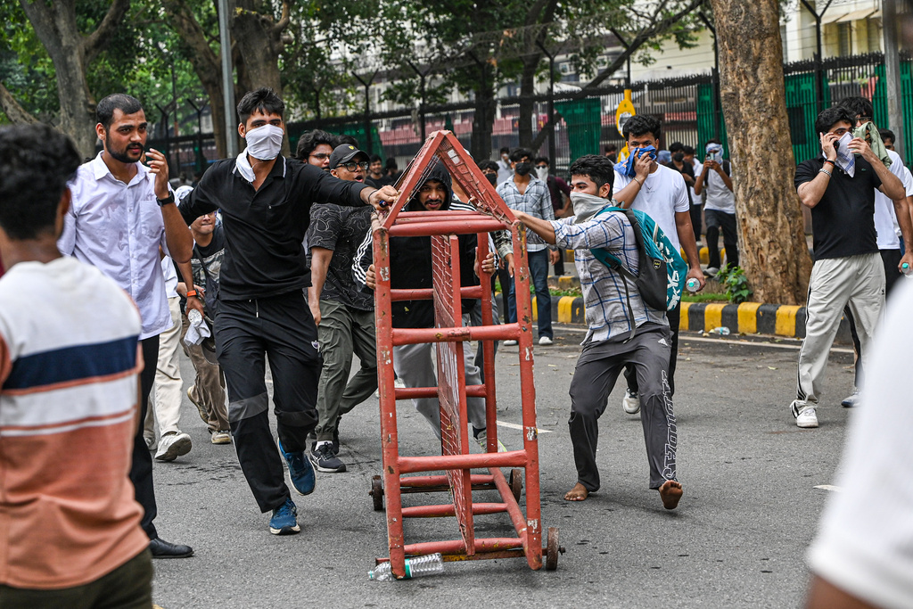 Supporters of the Cockroach Janta Party remove a police barricade as they attempt to march toward India's Parliament, demanding the resignation of the education minister, in New Delhi, India, Monday, July 20, 2026. (AP Photo/Prakash Singh)