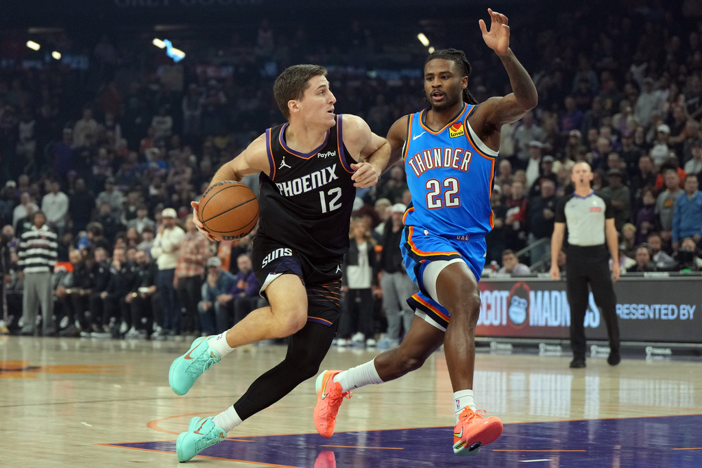 Phoenix Suns guard Collin Gillespie drives past Oklahoma City Thunder guard Cason Wallace (22) during the first half of an NBA basketball game, Sunday, Jan. 4, 2026, in Phoenix. (AP Photo/Rick Scuteri)
