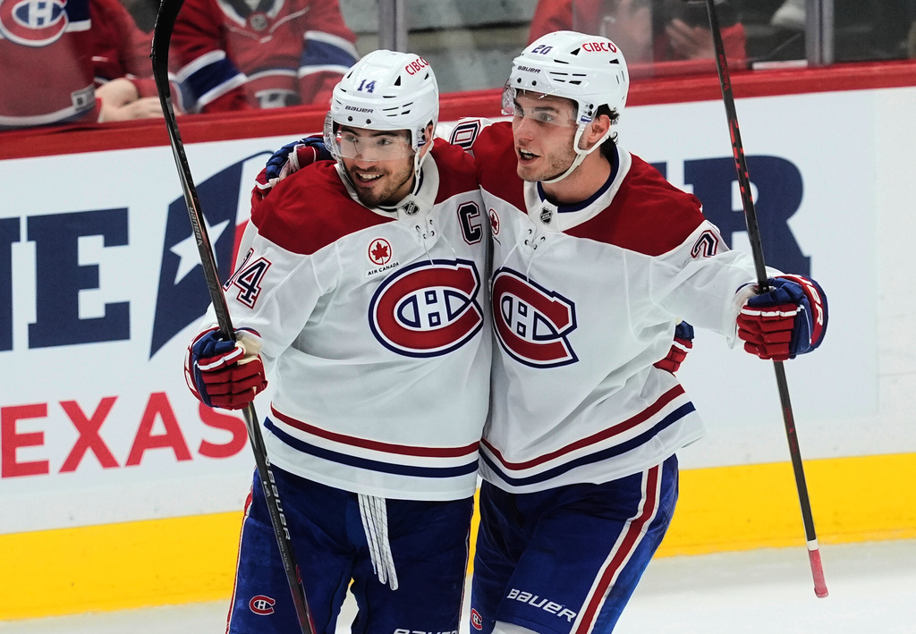 Montreal Canadiens left wing Juraj Slafkovsky (20) celebrates his goal with teammate Nick Suzuki (14) during third period NHL action against the Ottawa Senators in Ottawa, Saturday, Jan. 17, 2026. (Adrian Wyld/The Canadian Press via AP)