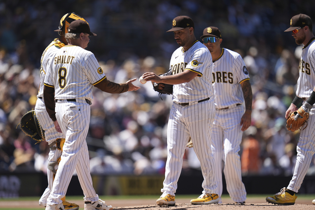 San Diego Padres starting pitcher Nestor Cortes, center, hands the ball to manager Mike Shildt (8) as he exits during the third inning of a baseball game against the Baltimore Orioles Wednesday, Sept. 3, 2025, in San Diego. (AP Photo/Gregory Bull)
