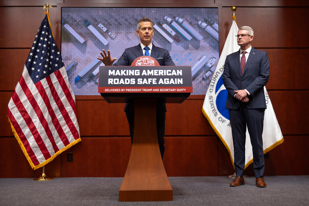 Transportation Secretary Sean Duffy speaks as Derek Barrs, Administrator of the Federal Motor Carrier Safety Administration, listens during a news conference at the Department of Transportation in Washington, Friday, Dec. 12, 2025. (AP Photo/Mark Schiefelbein)