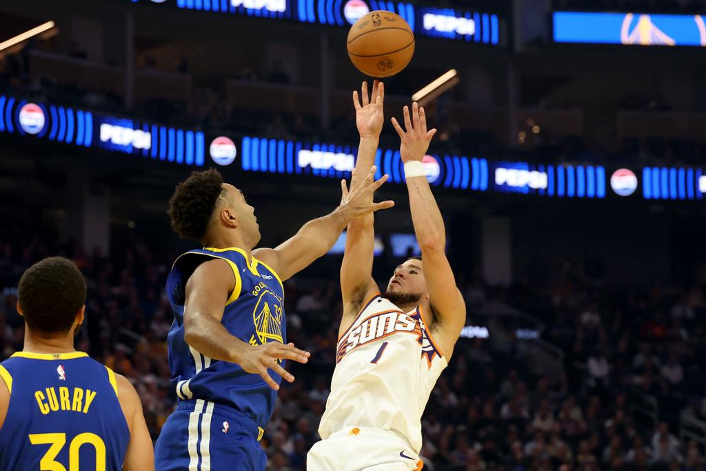 Phoenix Suns guard Devin Booker (1) shoots against Golden State Warriors forward Trayce Jackson-Davis (32) during the first half of an NBA basketball game in San Francisco, Tuesday, Nov. 4, 2025. (AP Photo/Jed Jacobsohn)