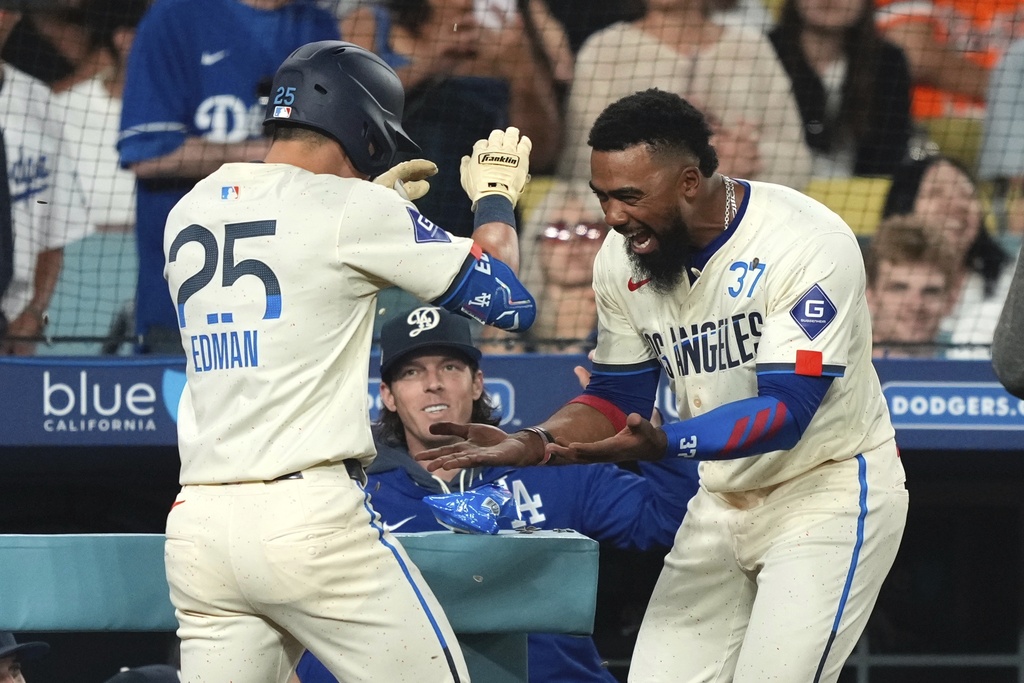 Los Angeles Dodgers' Tommy Edman is congratulated by Teoscar Hernández after hitting a solo home run during the fifth inning of a baseball game against the San Francisco Giants, Saturday, Sept. 20, 2025, in Los Angeles. (AP Photo/Mark J. Terrill)