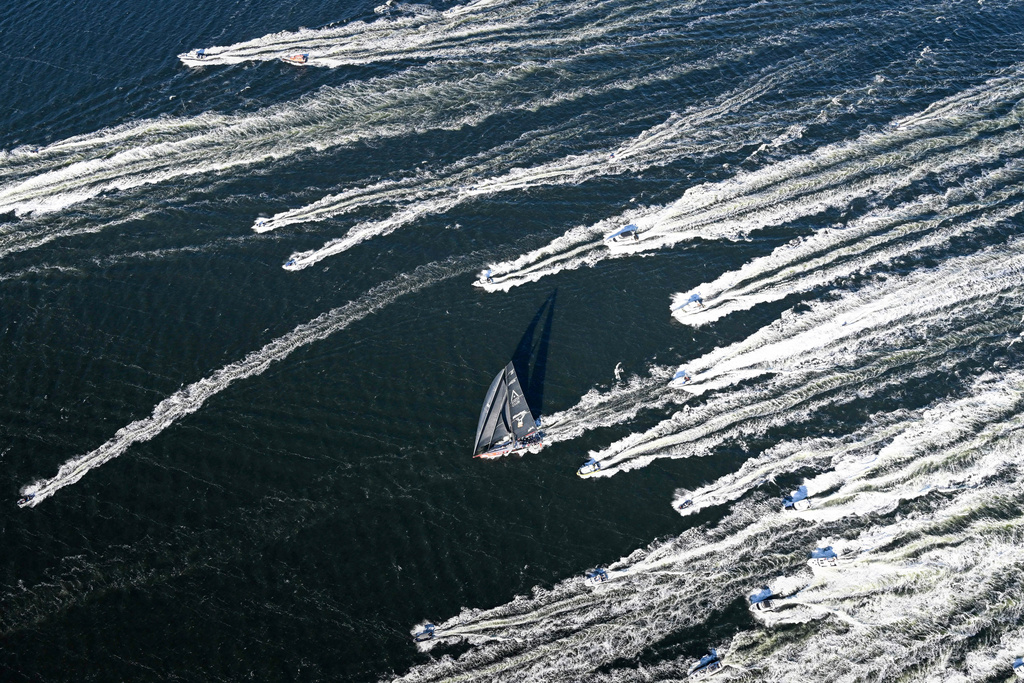 In this photo provided by the Cruising Yacht Club of Australia Comanche, center, is escorted by spectator craft as it crosses the finish line in Hobart, Australia, Sunday, Dec. 28, 2025, to claim line honors in the Sydney Hobart yacht race. (Kurt Arrigo/CYCA via AP)