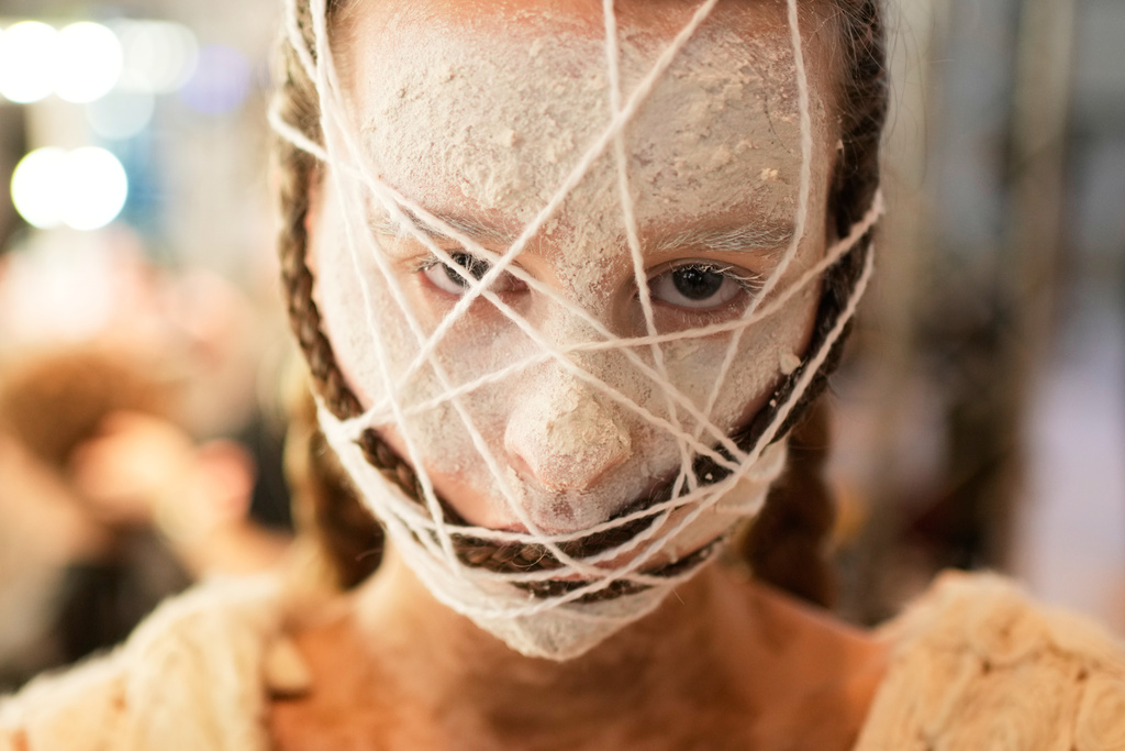 A model eyes the camera backstage before walking the runway at Moscow Fashion Week in Moscow, Wednesday, March 18, 2026. (AP Photo/Pavel Bednyakov)