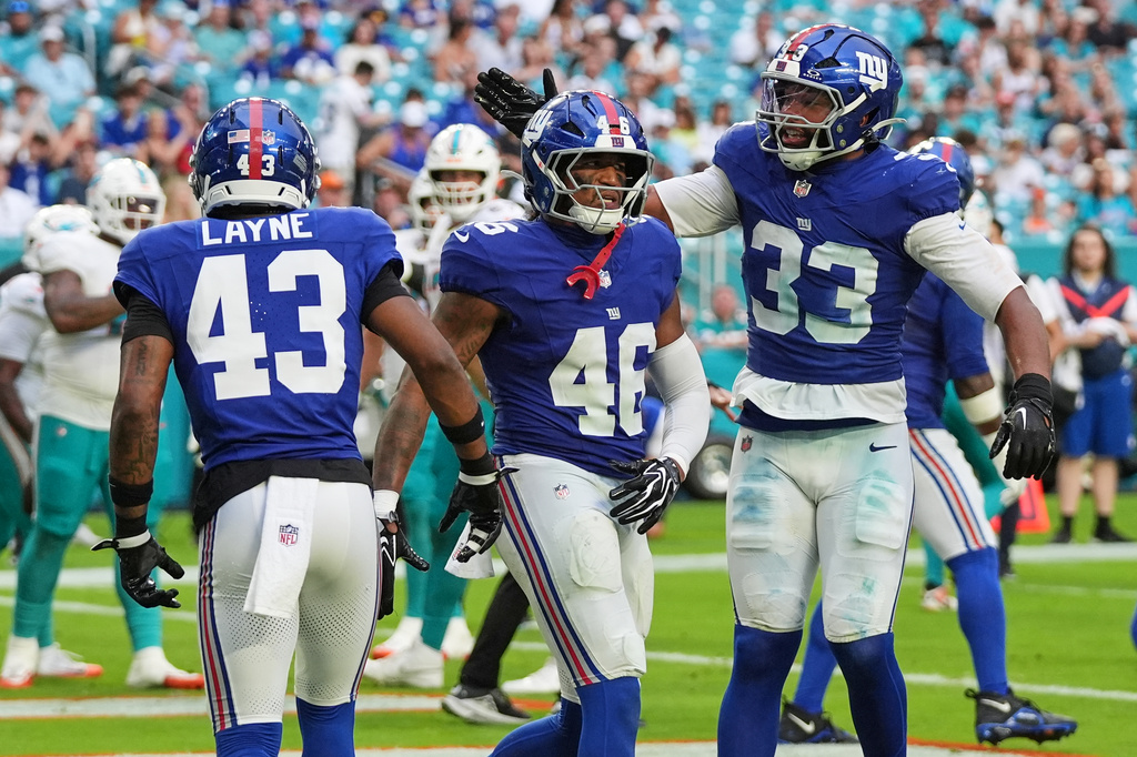 New York Giants linebacker Zaire Barnes (46) celebrates with Giants linebacker Caleb Murphy (33) during the second half of a preseason NFL football game against the Miami Dolphins, Saturday, Aug. 22, 2026, in Miami Gardens, Fla. (AP Photo/Lynne Sladky)