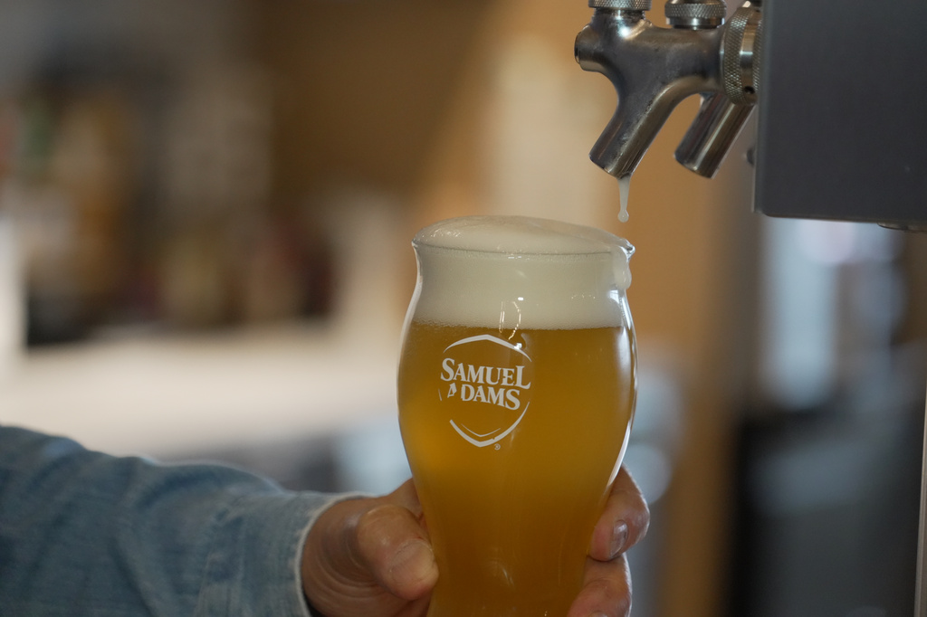 Beer froths after Boston Beer Co. Founder and CEO Jim Koch poured himself a drink at his company headquarters in Boston, Tuesday, July 7, 2026. (AP Photo/Rodrique Ngowi)