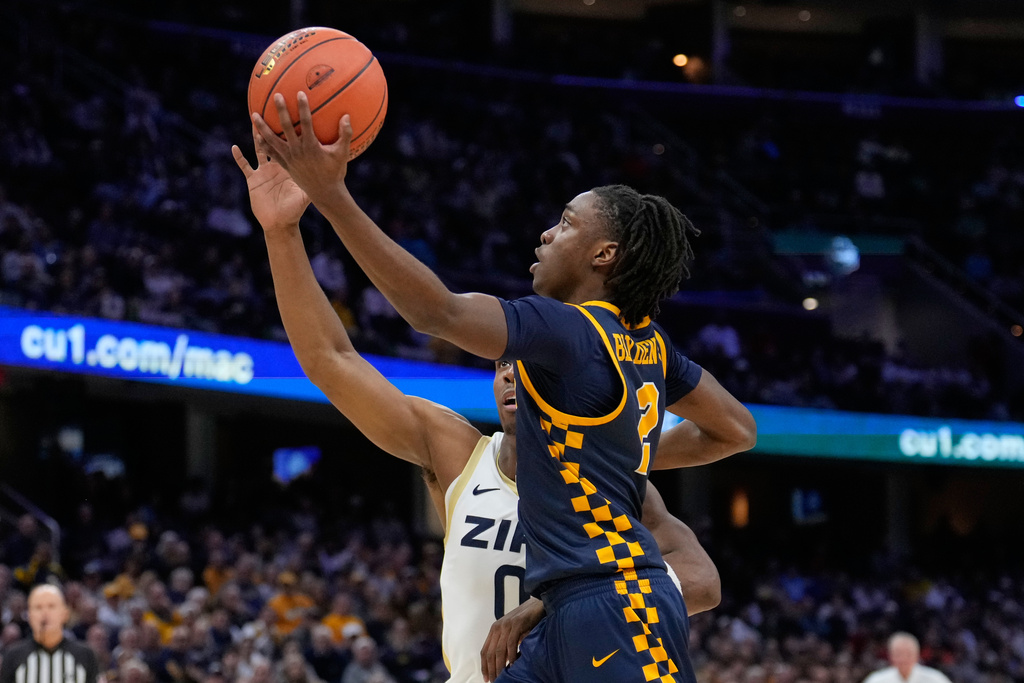 Toledo guard Leroy Blyden Jr. (2) goes to the basket past Akron forward Amani Lyles, rear, in the first half of an NCAA college basketball game in the championship of the Mid-American Conference tournament, Saturday, March 14, 2026, in Cleveland. (AP Photo/Sue Ogrocki)