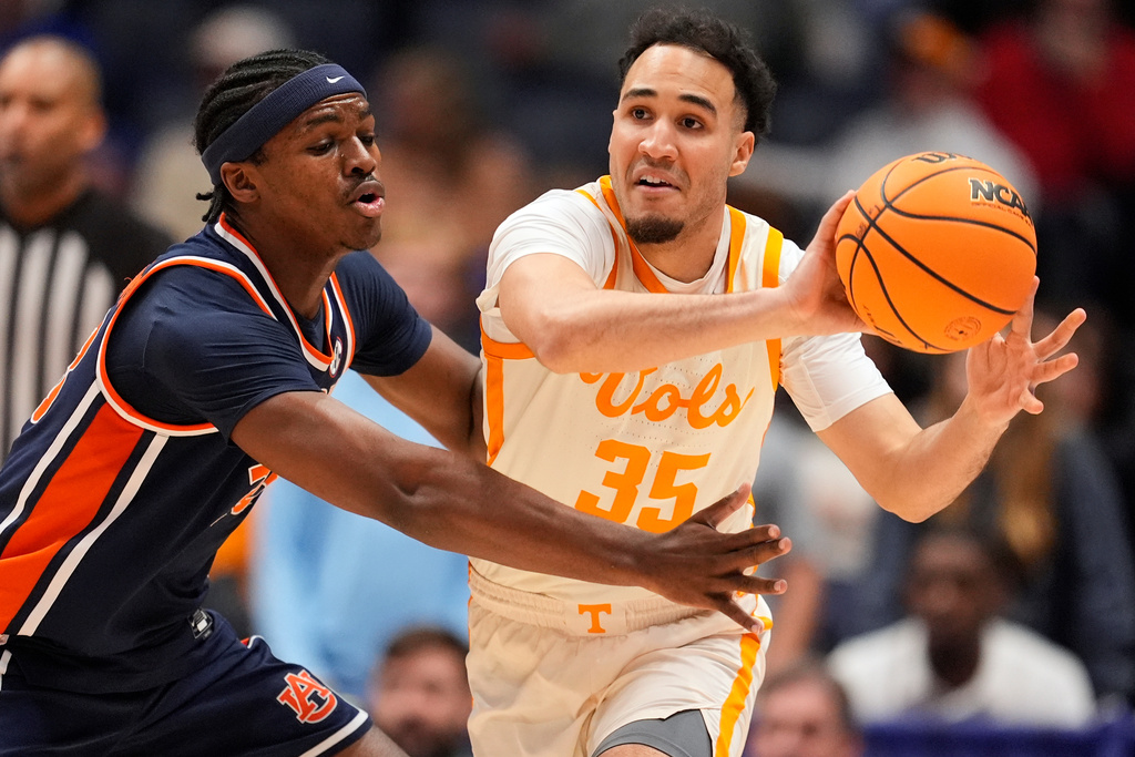 Tennessee guard Ethan Burg (35) passes the ball past Auburn forward Sebastian Williams-Adams, left, during the first half of an NCAA college basketball game in the second round of the Southeastern Conference tournament Thursday, March 12, 2026, in Nashville, Tenn. (AP Photo/George Walker IV)