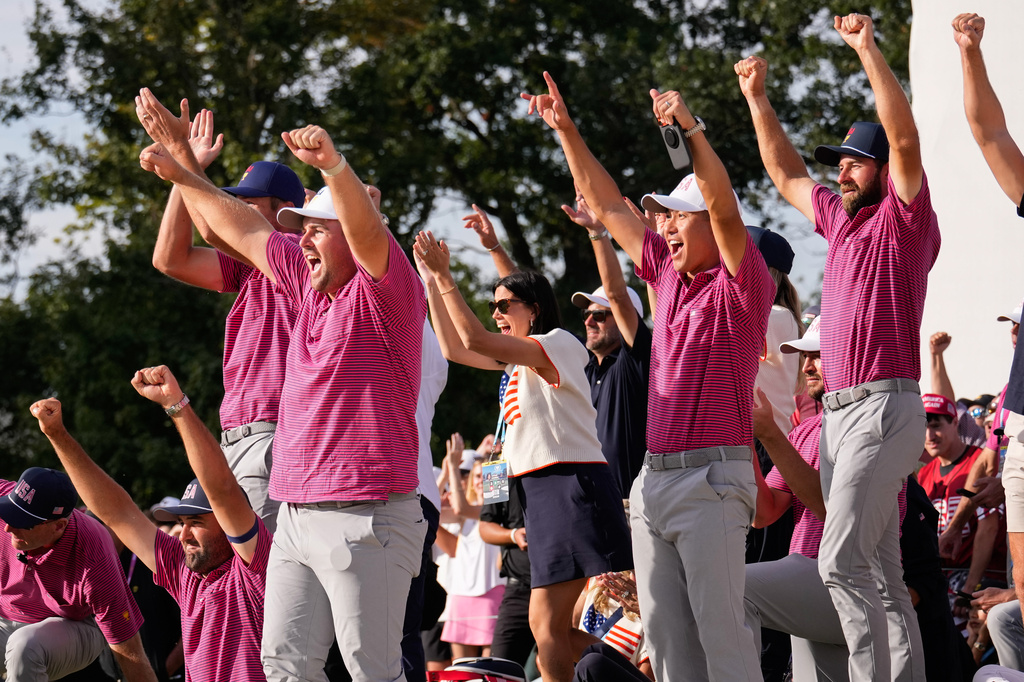 Members of the USA team celebrateJackson Koivun's win on the 18th green against the International team during a Presidents Cup golf tournament final round singles match at Medinah Country Club, Sunday, Sept. 27, 2026, in Medinah, Ill. (AP Photo/Matt Slocum)