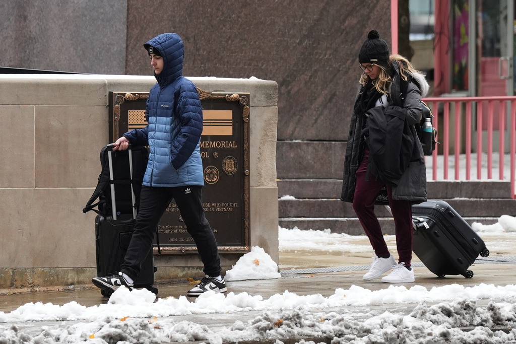 Pedestrians walk on the sidewalk during a cold day in Chicago, Tuesday, Nov. 11, 2025. (AP Photo/Nam Y. Huh)