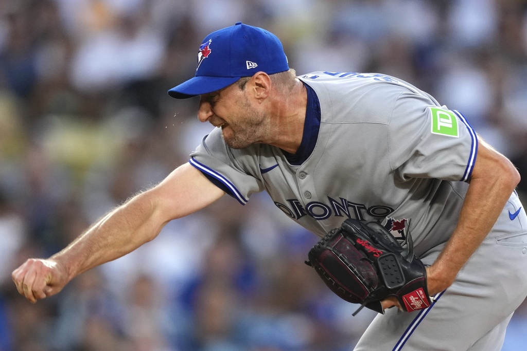 Sweat flies off the face of Toronto Blue Jays starting pitcher Max Scherzer as he throws to the plate during the first inning of a baseball game against the Los Angeles Dodgers, Friday, Aug. 8, 2025, in Los Angeles. (AP Photo/Mark J. Terrill)