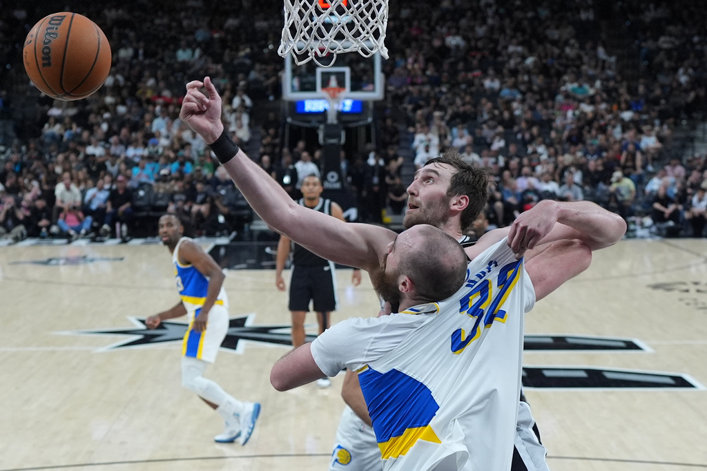 Indiana Pacers center Jay Huff (32) and San Antonio Spurs center Luke Kornet (7) battle for a rebound during the first half of an NBA basketball game in San Antonio, Saturday, March 21,2026. (AP Photo/Eric Gay)