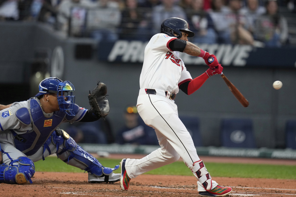 Cleveland Guardians' Jose Ramirez, right, hits an RBI single in front of Kansas City Royals catcher Salvador Perez in the third inning of a baseball game in Cleveland, Monday, Sept. 8, 2025. (AP Photo/Sue Ogrocki)