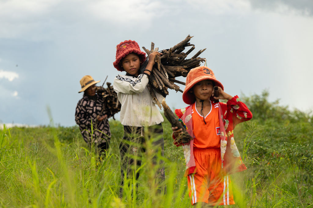 Sou Sreynich, center, collects firewood with her mother and sister near their home in a floating village on Cambodia's Tonle Sap Lake on Monday, June 29, 2026. (AP Photo/Anton L. Delgado)