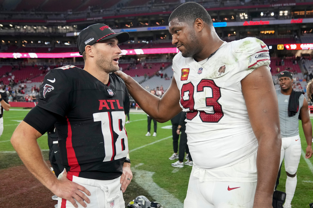 Atlanta Falcons quarterback Kirk Cousins (18) and Arizona Cardinals defensive tackle Calais Campbell (93) speak after an NFL football game, Sunday, Dec. 21, 2025, in Glendale, Ariz. (AP Photo/Rick Scuteri)