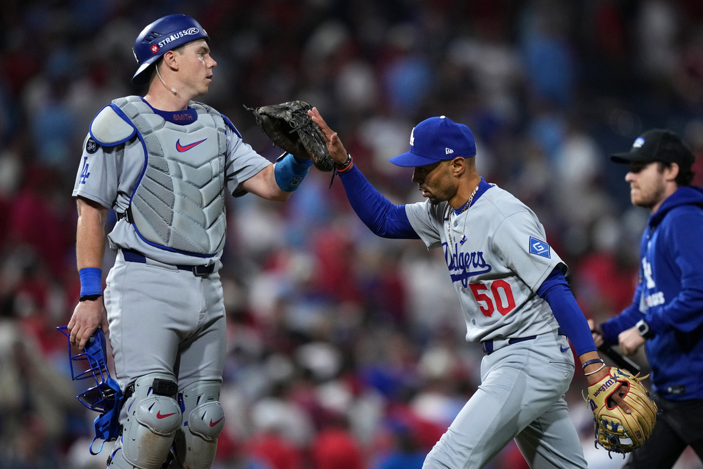 Los Angeles Dodgers' Will Smith, left, and Mookie Betts celebrate after the Dodgers won Game 1 of baseball's National League Division Series against the Philadelphia Phillies, Saturday, Oct. 4, 2025, in Philadelphia. (AP Photo/Matt Slocum)