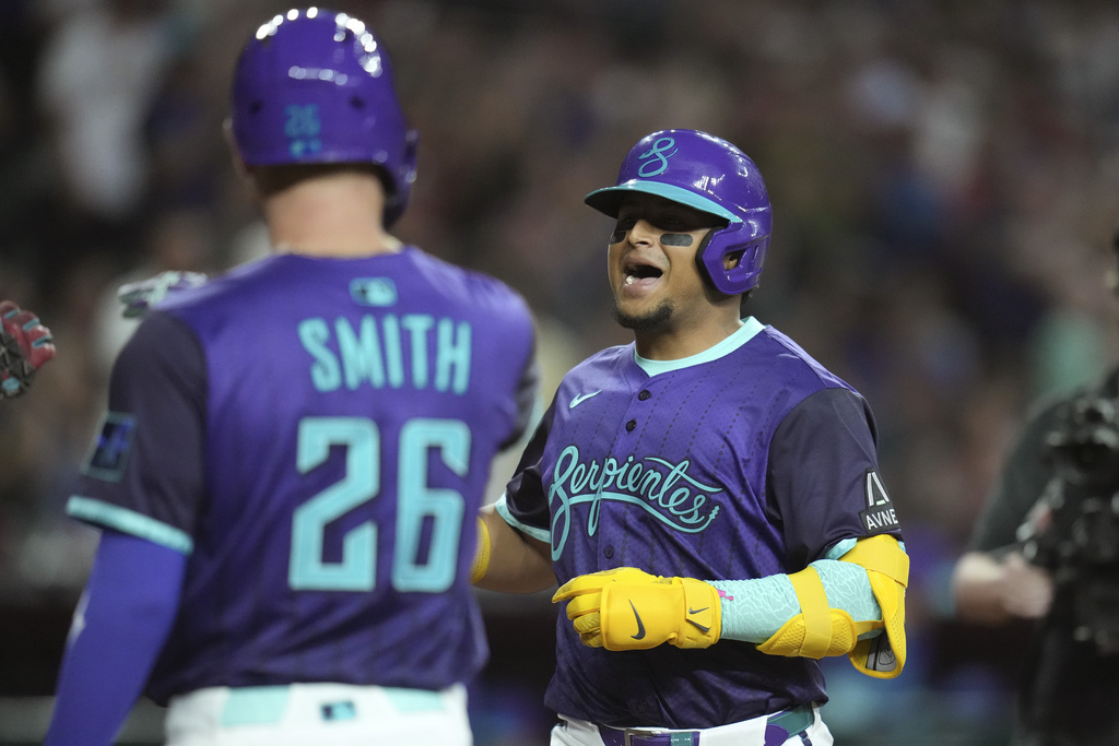 Arizona Diamondbacks' Gabriel Moreno, right, celebrates his three-run home run against the Cincinnati Reds with Diamondbacks' Pavin Smith (26) during the third inning of a baseball game Friday, Aug. 22, 2025, in Phoenix. (AP Photo/Ross D. Franklin)
