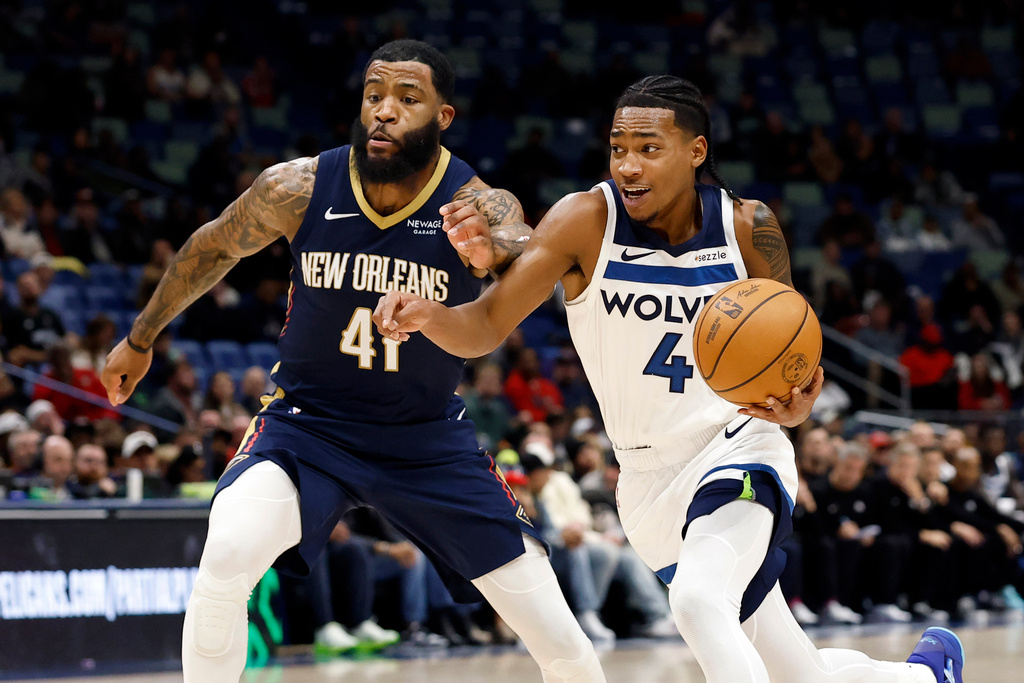 Minnesota Timberwolves guard Rob Dillingham (4) drives to the basket as New Orleans Pelicans guard Saddiq Bey (41) defends in the first half of an NBA basketball game, in New Orleans, Tuesday, Dec. 2, 2025. (AP Photo/Tyler Kaufman)