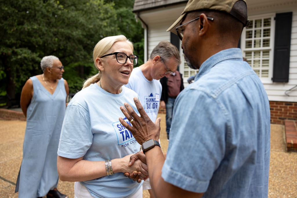 Democratic congressional candidate Shannon Taylor speaks with supporter Bill Ramsey at a door-knocking event Saturday, July 25, 2026, in Williamsburg, Va. (AP Photo/Mike Kropf)
