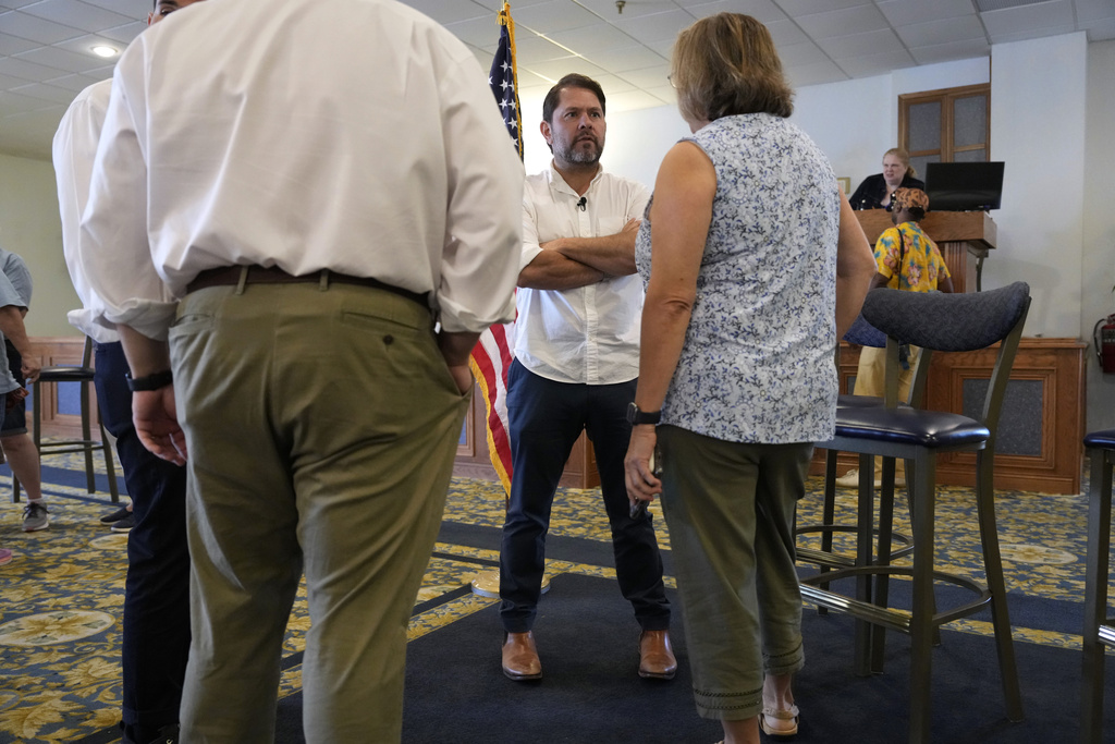 Sen. Ruben Gallego, D-Ariz., talks with an audience member during a town hall meeting, Saturday, Aug. 9, 2025, in Davenport, Iowa. (AP Photo/Charlie Neibergall)