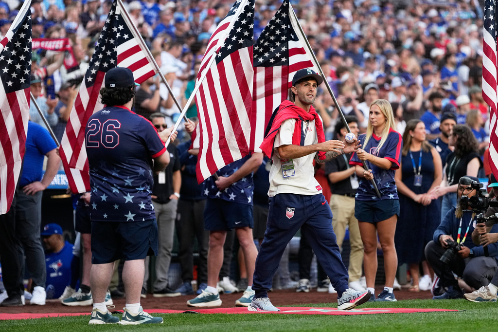 United States men's national soccer team's Christian Pulisic walks to the field before head coach Mauricio Pochettino threw out the ceremonial first pitch before a baseball game between the Seattle Mariners and the Toronto Blue Jays, Friday, July 3, 2026, in Seattle. (AP Photo/Lindsey Wasson)