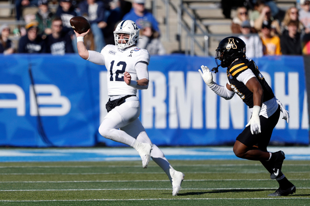 Georgia Southern quarterback JC French IV (12) throws a pass as he is flushed form the pocket by Appalachian State defensive lineman Aiden Benton (33) during the first half of the Birmingham Bowl NCAA college football game, Monday, Dec. 29, 2025, in Birmingham. (AP Photo/Butch Dill)