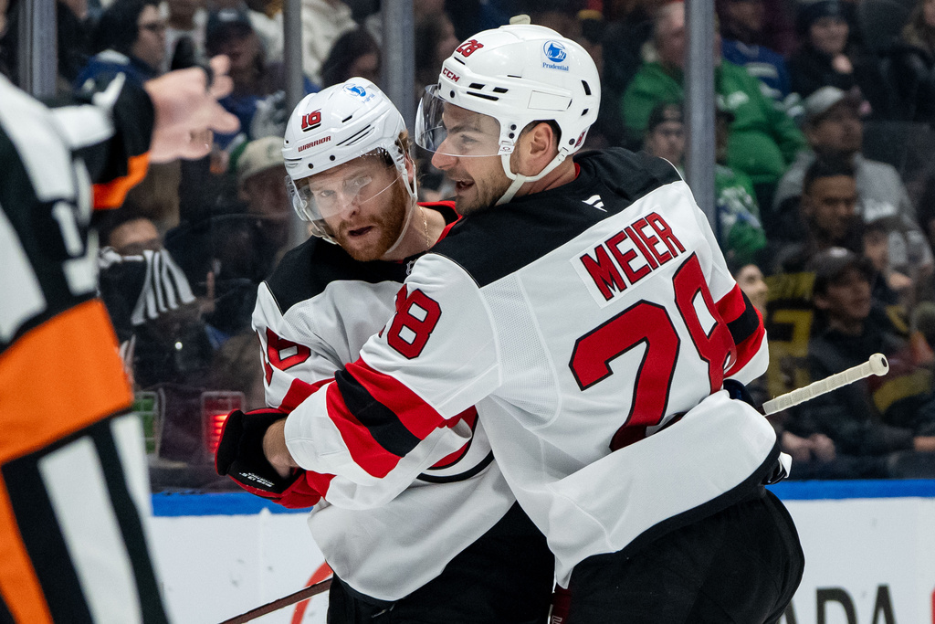 New Jersey Devils' Connor Brown (16) celebrates his goal against the Vancouver Canucks with Timo Meier (28) during the second period of an NHL hockey game in Vancouver, British Columbia, Friday, Jan. 23, 2026. (Ethan Cairns/The Canadian Press via AP)