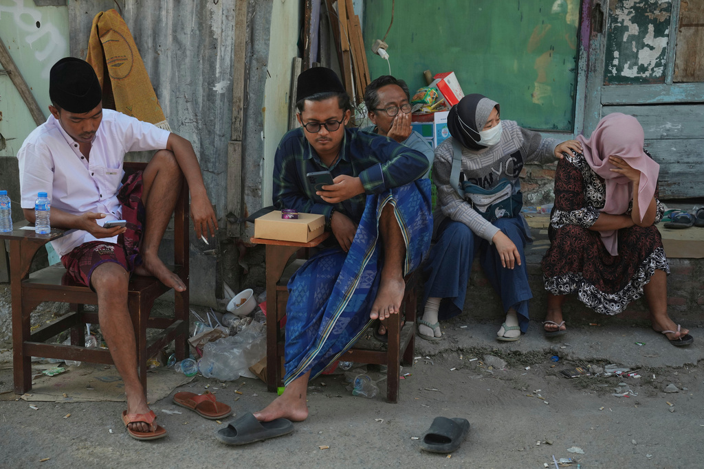 Family members of students wait as rescue works are underway for victims trapped under the rubble after a building under construction collapsed at an Islamic boarding school in Sidoarjo, East Java, Indonesia, Thursday, Oct. 2, 2025. (AP Photo/Achmad Ibrahim)