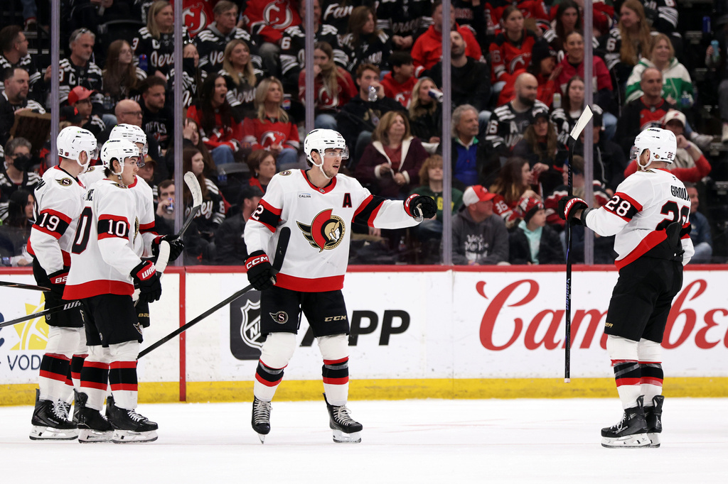 Ottawa Senators center Shane Pinto (12) is congratulated by Claude Giroux (28) after scoring during the second period of an NHL hockey game against the New Jersey Devils Sunday, April 12, 2026, in Newark, N.J. (AP Photo/Adam Hunger)
