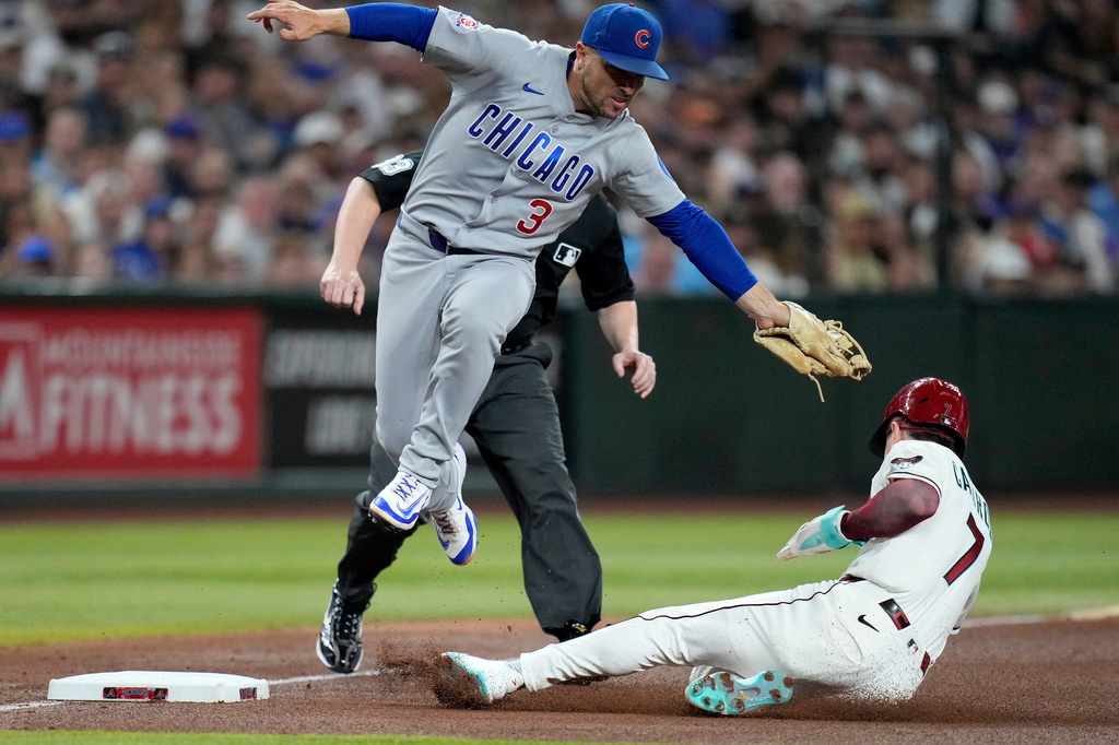 Arizona Diamondbacks' Corbin Carroll, right, steals third base as Chicago Cubs third baseman Alex Bregman (3) makes a late tag during the fourth inning of a baseball game, Monday, Aug. 24, 2026, in Phoenix. (AP Photo/Ross D. Franklin)
