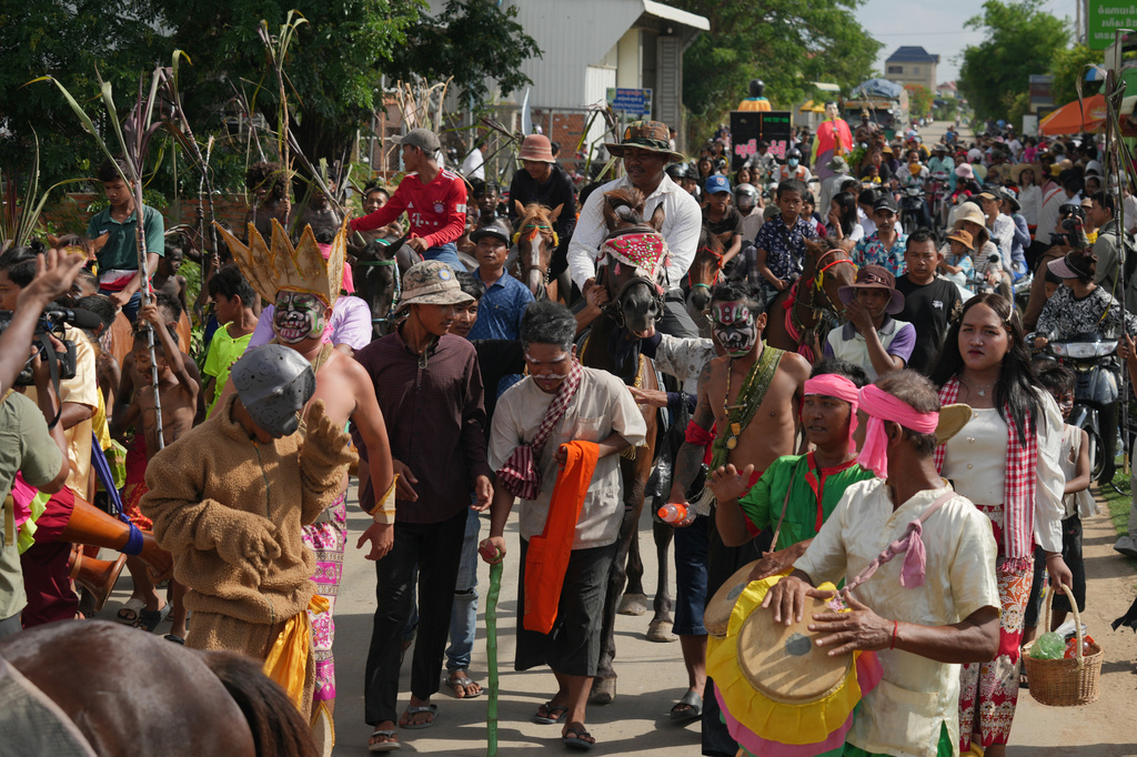 Villagers march to mark a ceremony to invoke rain amid the rice planting season in Pring Ka-ek village, northwest of Phnom Penh, Cambodia, Thursday, May 21, 2026. (AP Photo/Heng Sinith)