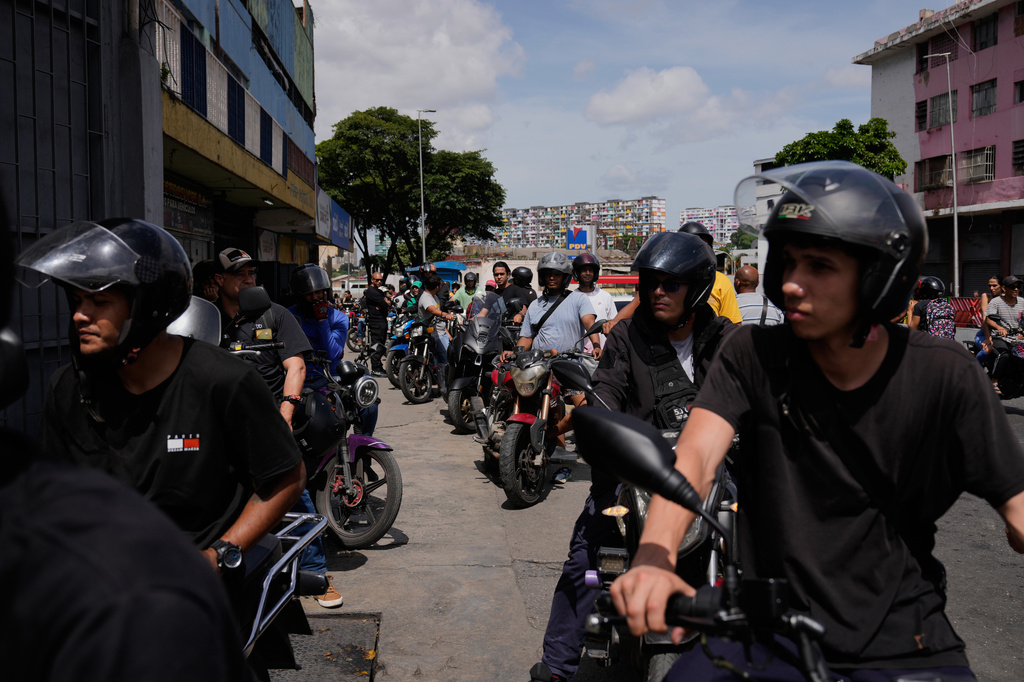 Motorcyclists wait in line to fill their tanks in Caracas, Venezuela, Thursday, June 25, 2026, a day after successive powerful earthquakes struck the country. (AP Photo/Ariana Cubillos)