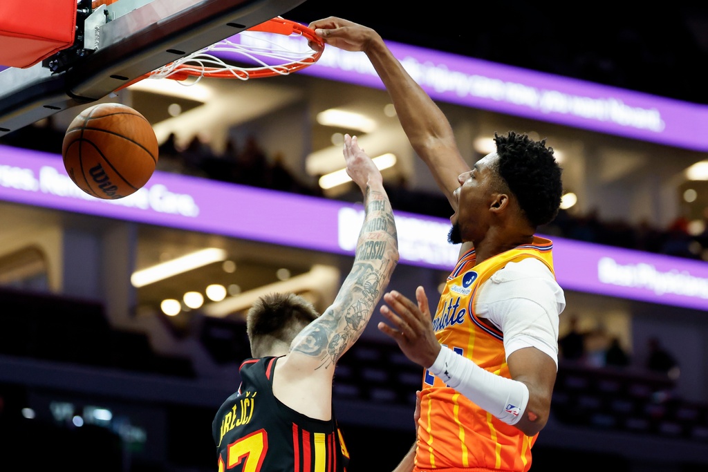 Charlotte Hornets forward Brandon Miller, right, dunks over Atlanta Hawks guard Vit Krejci during the first half of an NBA basketball game in Charlotte, N.C., Thursday, Dec. 18, 2025. (AP Photo/Nell Redmond)
