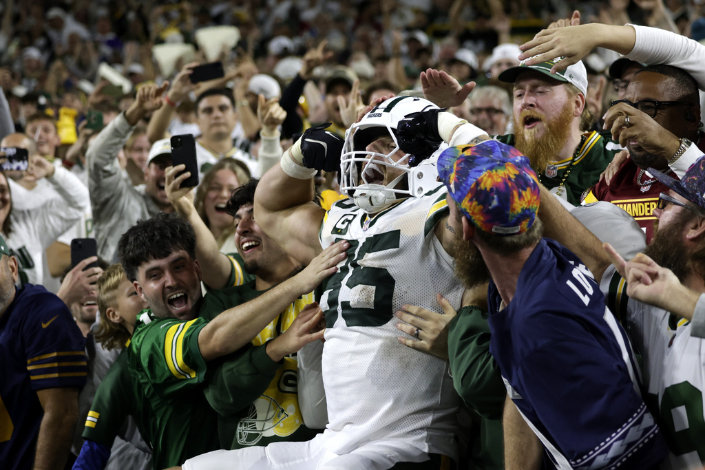 Green Bay Packers tight end Tucker Kraft celebrates with fans after catching a touchdown pass during the second half of an NFL football game against the Washington Commanders Thursday, Sept. 11, 2025, in Green Bay, Wis. (AP Photo/Matt Ludtke)
