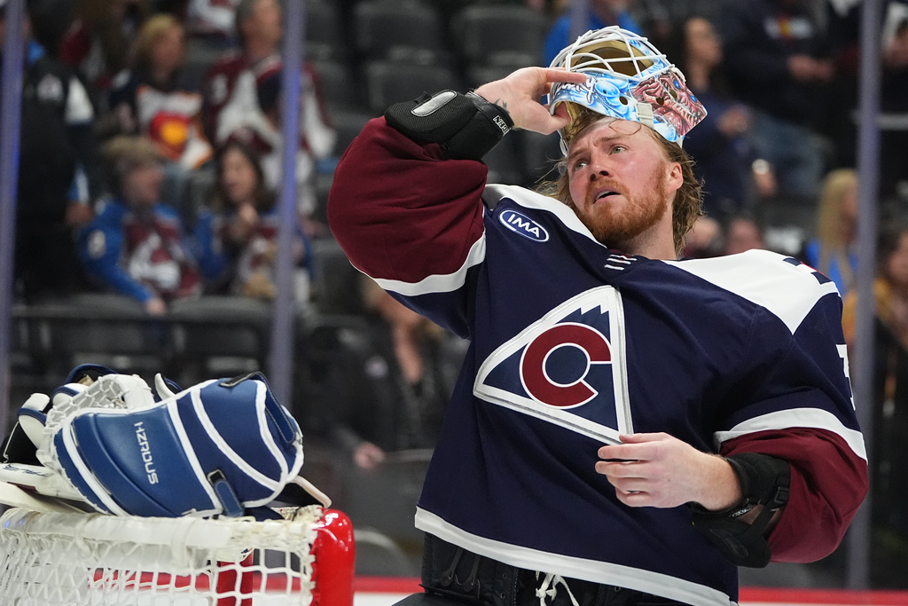 Colorado Avalanche goaltender MacKenzie Blackwood pulls on his mask during a break in the second period of an NHL hockey game against the Minnesota Wild, Thursday, Feb. 26, 2026, in Denver. (AP Photo/David Zalubowski)