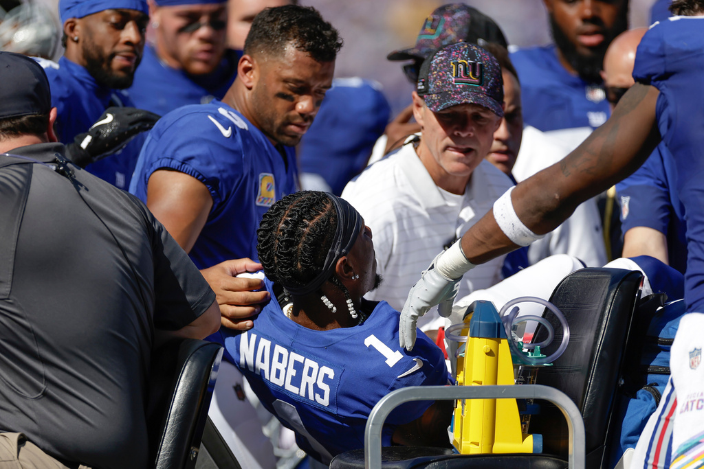 Teammates and trainers tend to New York Giants wide receiver Malik Nabers (1) after an injury during the second quarter of an NFL football game against the Los Angeles Chargers, Sunday, Sept. 28, 2025, in East Rutherford, N.J. (AP Photo/Adam Hunger)